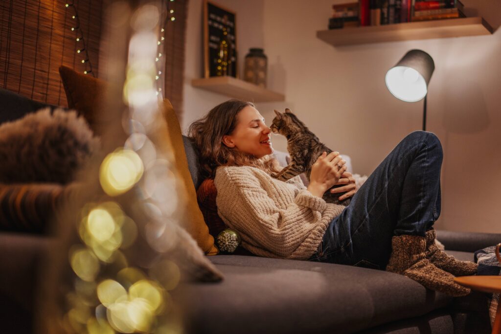 Eine Frau sitzt mit ihrer Katze auf der Couch