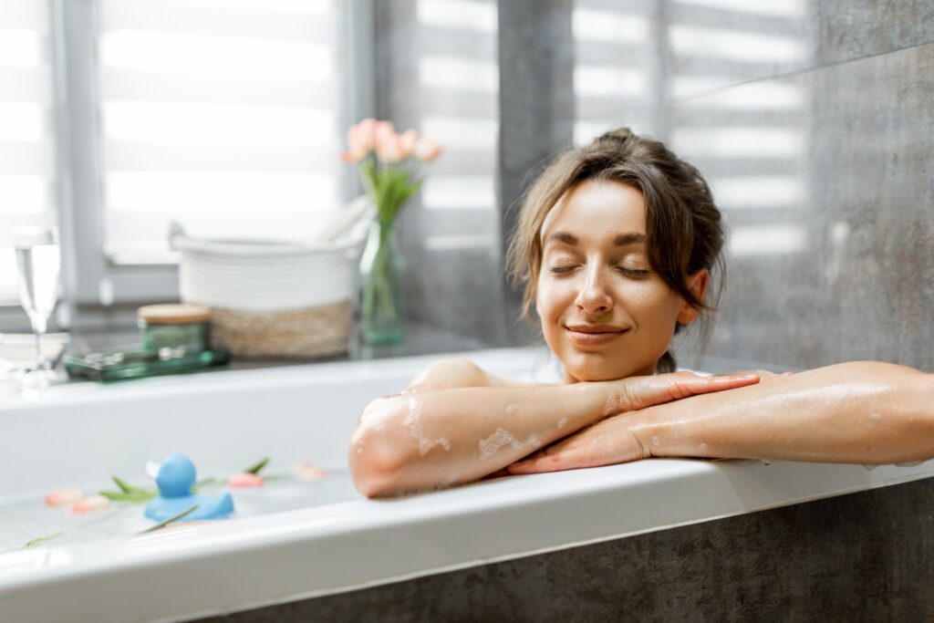 Frau beim Baden mit Dusch WC Aufsatz |
